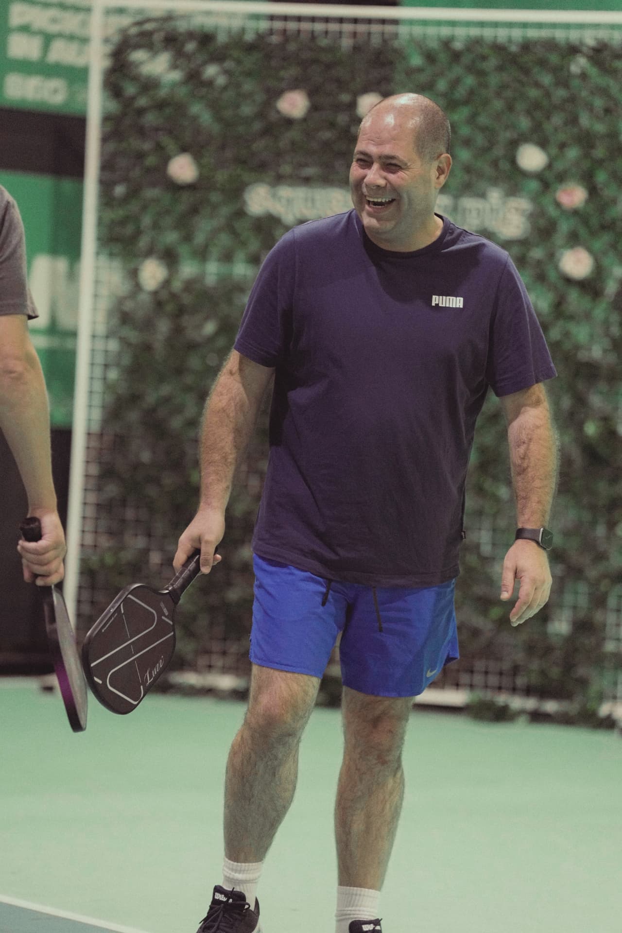 Player laughing mid-session holding a Luzz paddle at The Jar